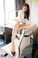 A woman sitting on top of a chair in a room.