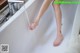 A woman's feet in a bathtub with water coming out of it.