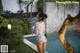 A woman in a bathing suit standing next to a pool.