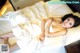 A woman laying on a bed in a white dress.