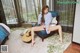 A woman sitting on a blue chair with a guitar.