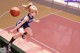 A girl in a blue uniform dribbling a basketball on a court.