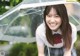 A woman in a school uniform holding an umbrella.