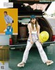 A woman sitting in the trunk of a car holding a yellow balloon.